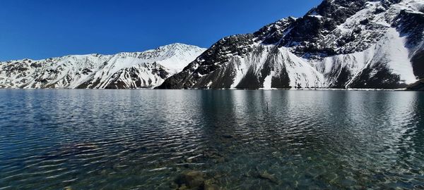 Scenic view of snowcapped mountains against clear blue sky