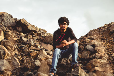 Young man sitting on rock