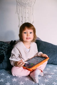 Child using technology. toddler at home with a tablet and a pen stylus and draws