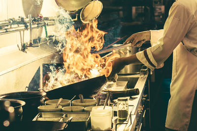 Chef stir fry busy cooking in kitchen. chef stir fry the food in a frying pan