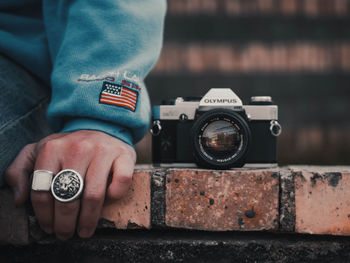 Close-up of hand holding camera against blurred background