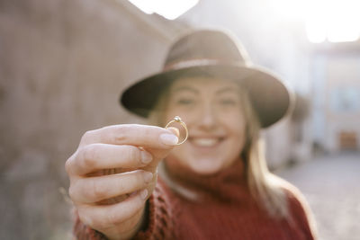 Portrait of smiling young woman holding ring 