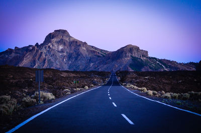 Empty road leading towards mountains