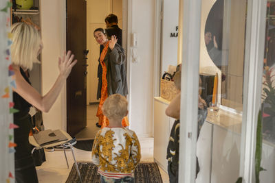 Woman waving while leaving apartment