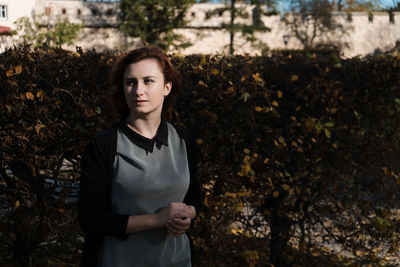 Young woman standing against building