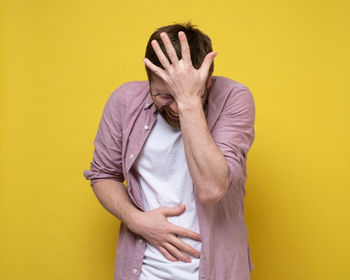 Low section of person standing against yellow background
