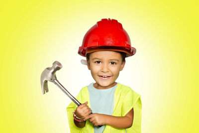 Portrait of smiling boy against yellow background