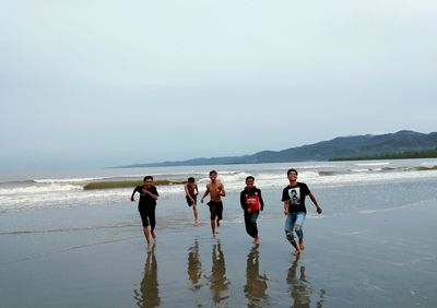 People on beach against clear sky