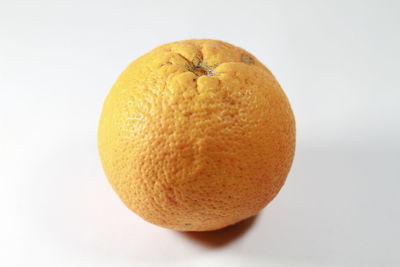 Close-up of orange apple against white background