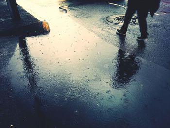 Low section of person walking on street during rainy season