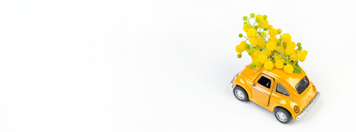 Close-up of yellow toy car against white background