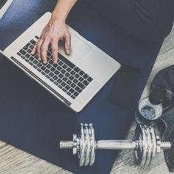 Midsection of man using laptop on table