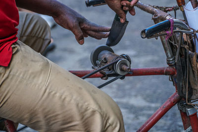 Cropped image of man repairing wheel