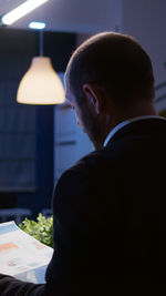 Rear view of man looking at illuminated restaurant