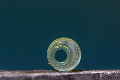 Close-up of glass bottle with no bottom 
 against wall