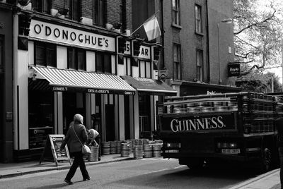 Rear view of man walking on street in city