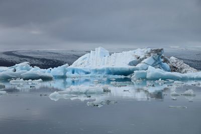 Glaciers in sea against sky