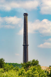 Low angle view of industrial chimney against sky