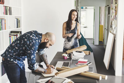 Male and female architects working at table