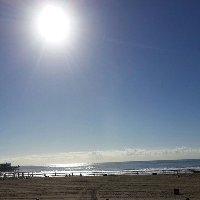 sea, horizon over water, beach, sun, water, sunlight, tranquil scene, tranquility, scenics, sky, sunbeam, blue, beauty in nature, shore, sand, sunny, nature, lens flare, incidental people, clear sky