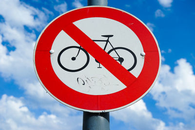 Close-up of road sign against sky