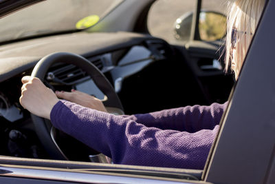 Cropped hand of man driving car