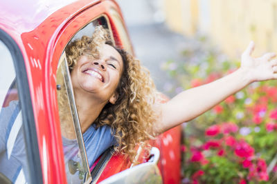 Happy woman with arm raised in car