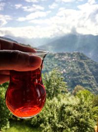 Close-up of hand holding glass of mountain