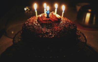 Close-up of illuminated birthday candles in cake