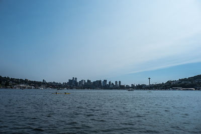 Scenic view of sea by buildings against sky