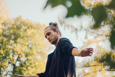 Thoughtful man standing by tree during autumn