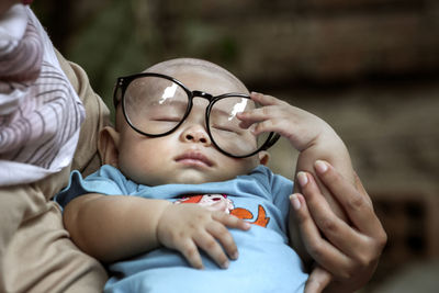 Sleeping baby boy wearing large eyeglasses