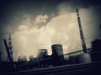 Low angle view of crane against cloudy sky