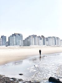 Man on beach against clear sky