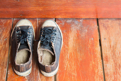 Low section of man wearing shoes on wooden floor
