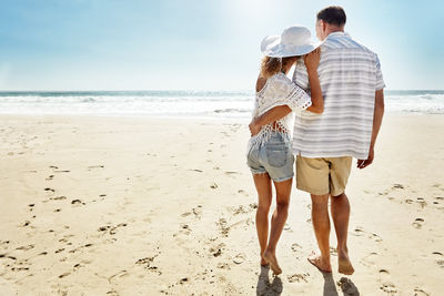 Rear view of woman standing at beach