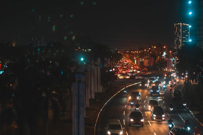 Illuminated street amidst buildings in city at night