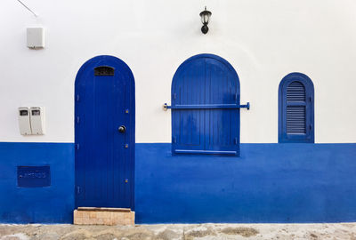 House's blue wooden door with a blue windows in the medina of asilah