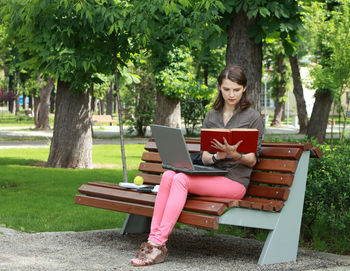 Woman sitting on bench in park