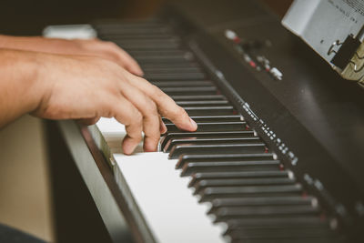 Cropped hand of person playing piano