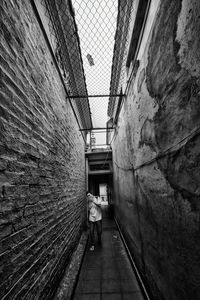 Woman walking on narrow alley
