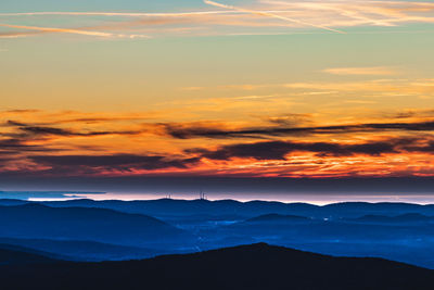 Scenic view of dramatic sky over silhouette landscape