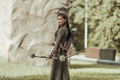 Woman holding umbrella while standing on land