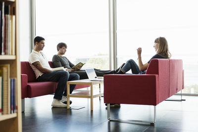 Male and female friends studying in university library