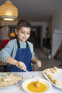 Boy holding food on table