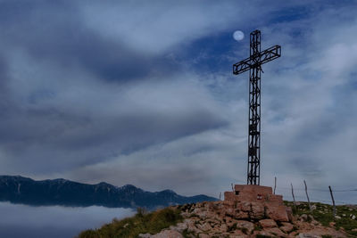 Low angle view of cross against sky