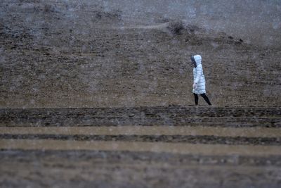 Rear view of a man walking on road