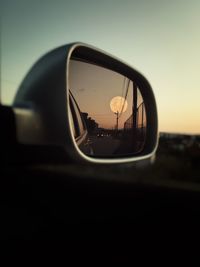 Close-up of moon reflecting on car side-view mirror