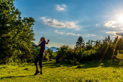 Side view of woman on land against sky