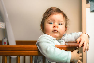 Portrait of cute girl sitting on chair at home